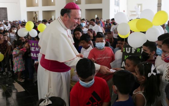 Archbishop Franco Coppola, the apostolic nuncio to Mexico, gives a rosary to a child during a visit to Aguililla April 23. Drug cartels have battled each other and blocked highways in the besieged town, leaving residents unable to travel freely and causin
